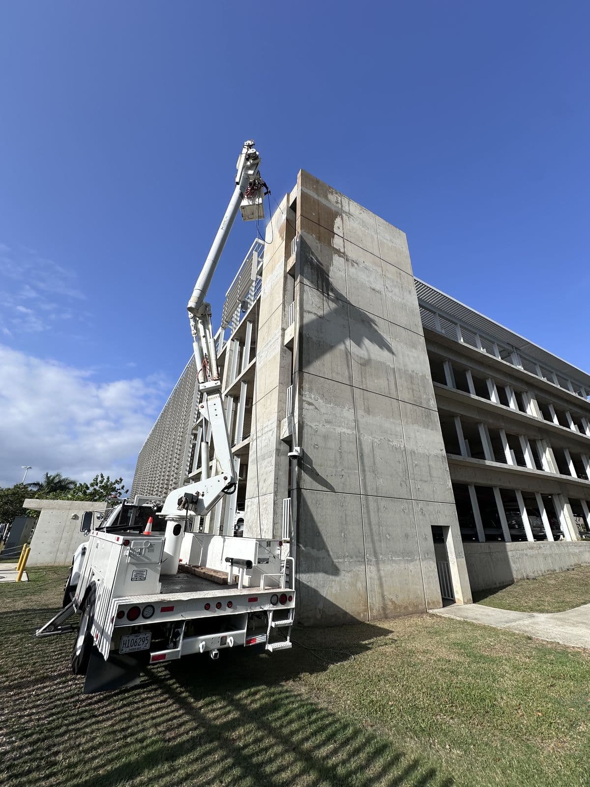 Camión canasto de KLJ trabajando en la fachada de un edificio